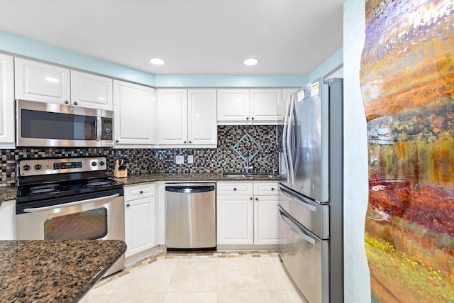 kitchen with white cabinetry, appliances with stainless steel finishes, and dark stone counters