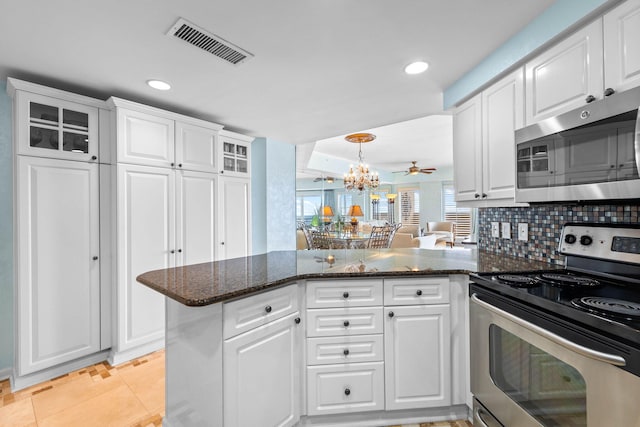 kitchen featuring tasteful backsplash, white cabinetry, appliances with stainless steel finishes, and kitchen peninsula