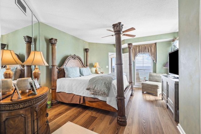 bedroom featuring ceiling fan, hardwood / wood-style floors, and a textured ceiling