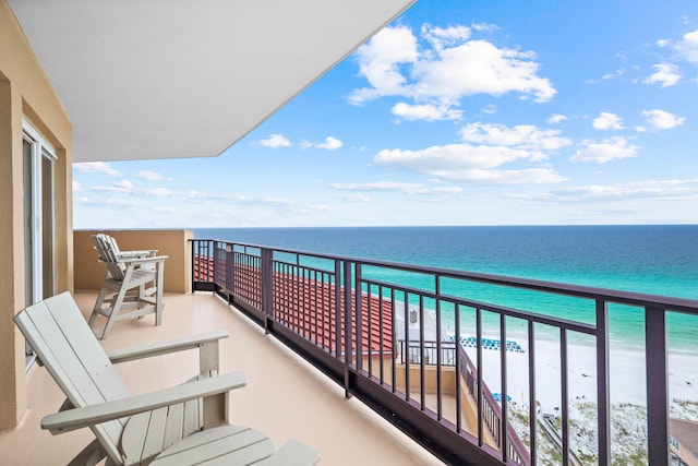 balcony featuring a water view and a beach view