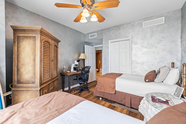 bedroom with ceiling fan, wood-type flooring, and a closet