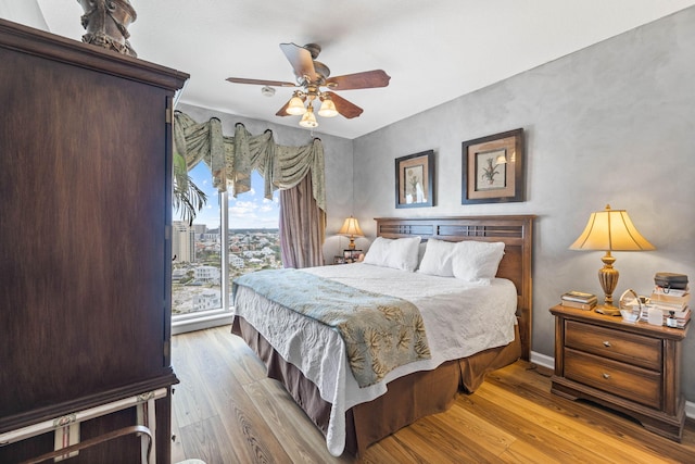 bedroom with ceiling fan, access to exterior, and light hardwood / wood-style flooring