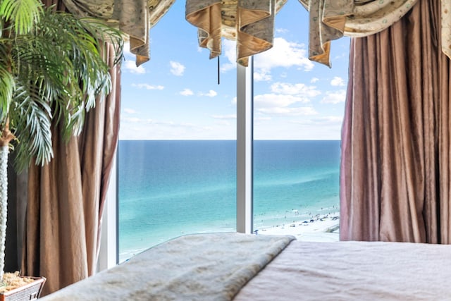 bedroom with a water view and a beach view