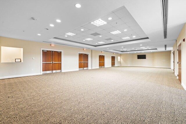 carpeted spare room featuring a tray ceiling