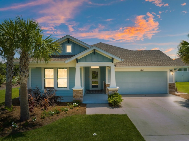 craftsman house with a garage and a yard