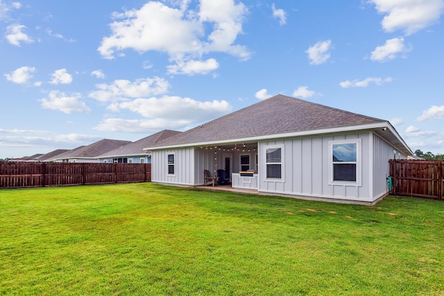 back of house with a patio area and a lawn