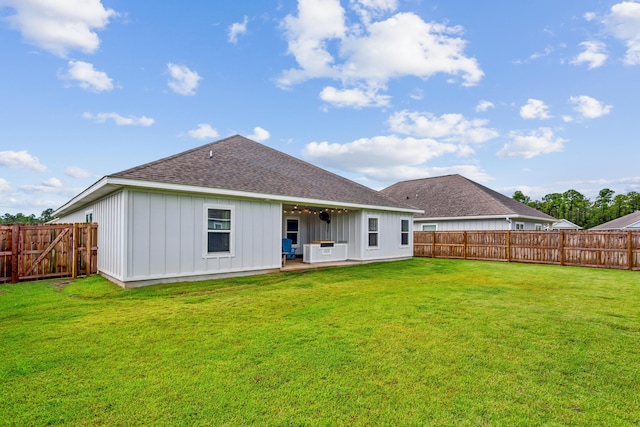 rear view of house featuring a lawn and a patio