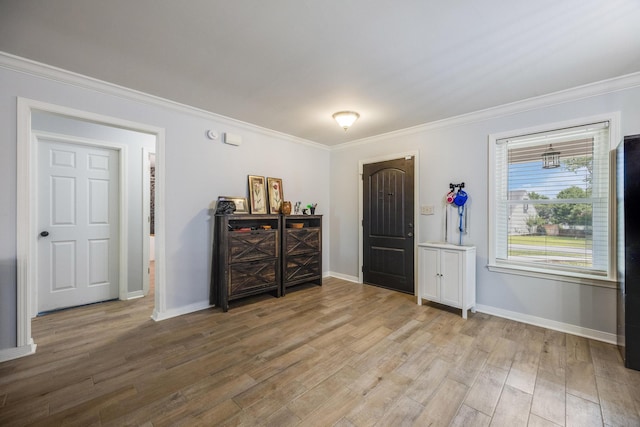 foyer with crown molding and light hardwood / wood-style flooring