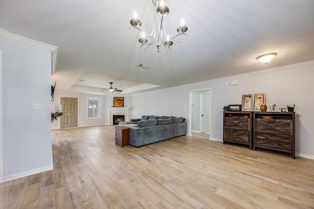 living room featuring light hardwood / wood-style floors, crown molding, a raised ceiling, and ceiling fan with notable chandelier