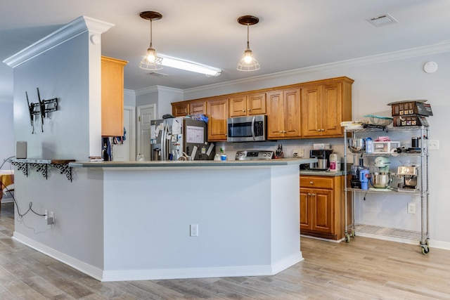 kitchen featuring appliances with stainless steel finishes, ornamental molding, and light hardwood / wood-style floors