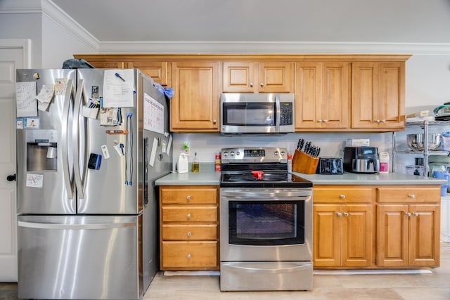 kitchen with appliances with stainless steel finishes and crown molding