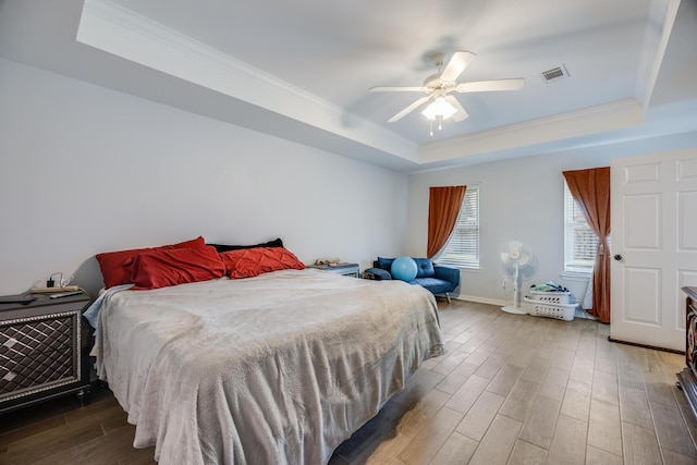 bedroom with ceiling fan and a tray ceiling