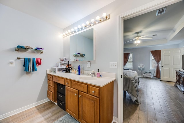 bathroom with ceiling fan, crown molding, vanity, and hardwood / wood-style floors