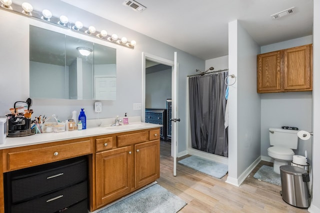 bathroom with toilet, vanity, hardwood / wood-style flooring, and a shower with curtain