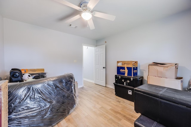 living room with ceiling fan and light hardwood / wood-style flooring