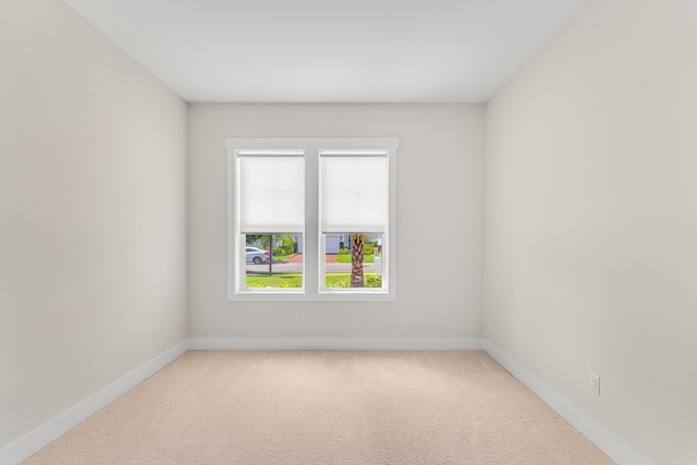 carpeted spare room featuring baseboards