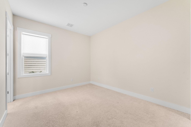 unfurnished room featuring baseboards, visible vents, and light colored carpet