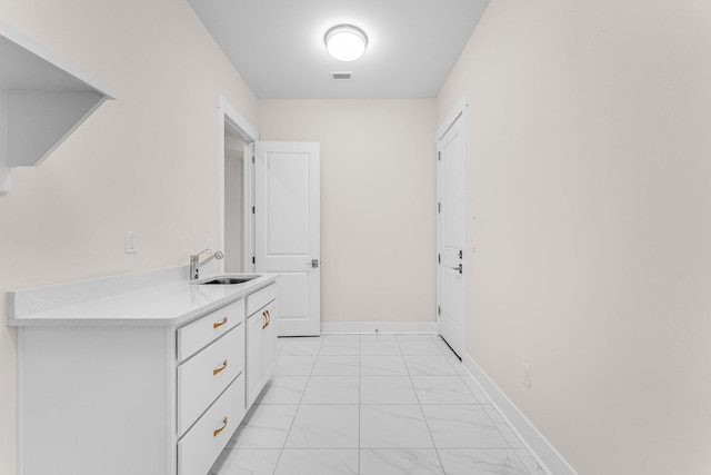 interior space with marble finish floor, visible vents, baseboards, and a sink