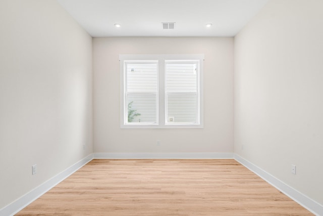 empty room featuring baseboards, visible vents, light wood-style flooring, and recessed lighting