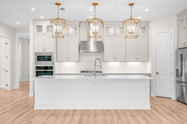 kitchen featuring glass insert cabinets, pendant lighting, and stainless steel appliances