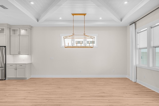 unfurnished dining area with baseboards, visible vents, beamed ceiling, and light wood finished floors