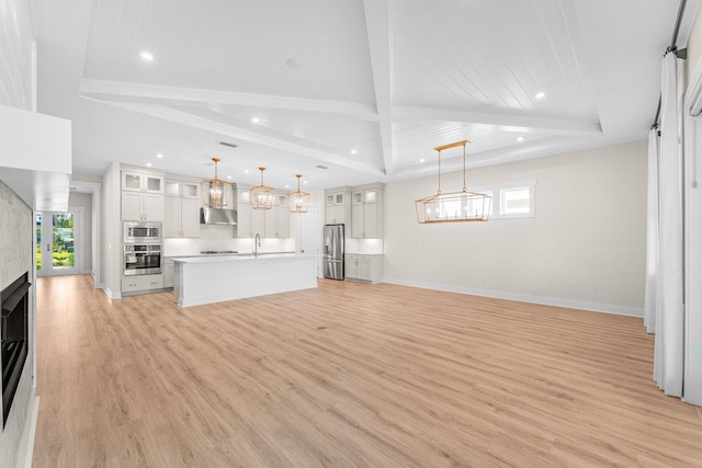 unfurnished living room with baseboards, recessed lighting, a raised ceiling, and light wood-style floors