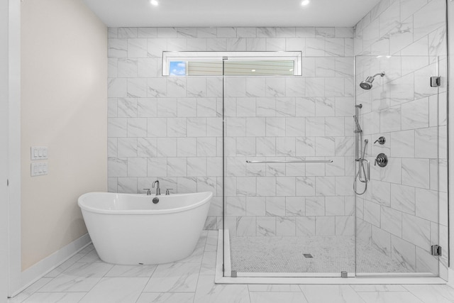 bathroom featuring a freestanding bath, marble finish floor, a stall shower, and plenty of natural light