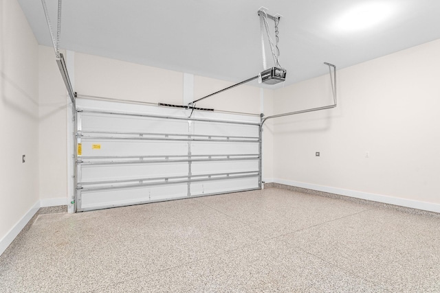 garage featuring a garage door opener and baseboards