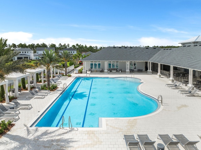 community pool featuring a patio, a residential view, and a pergola