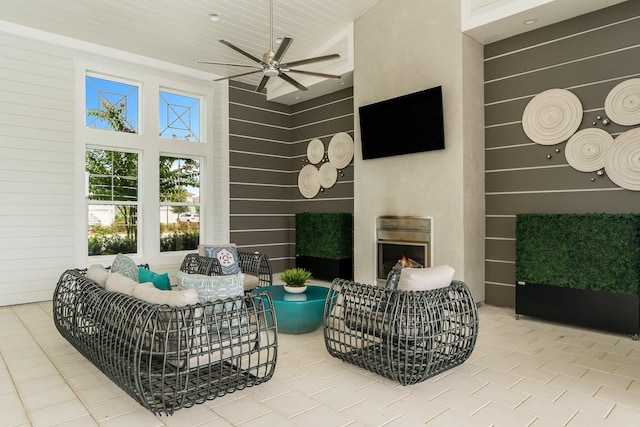 view of patio featuring a ceiling fan and an outdoor living space with a fireplace