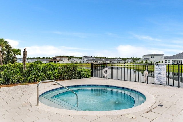 view of pool with a water view, fence, and a residential view