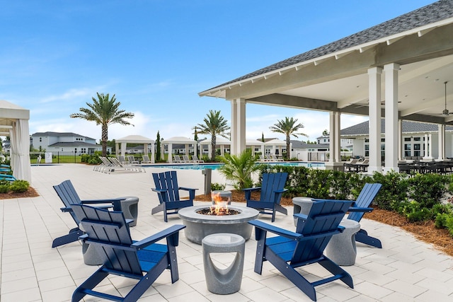 view of patio featuring a fire pit, a gazebo, a residential view, and a community pool