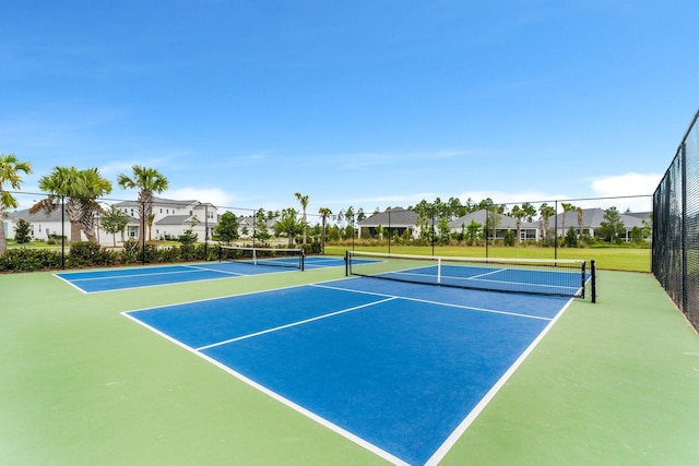 view of sport court featuring fence and a residential view