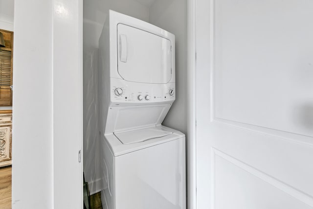 clothes washing area featuring stacked washer and clothes dryer