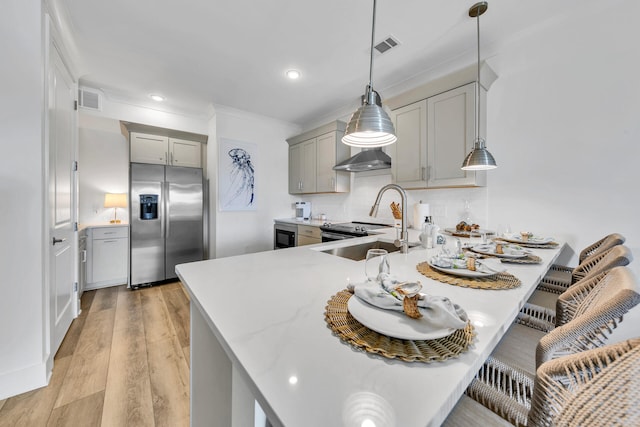 kitchen featuring light hardwood / wood-style flooring, gray cabinetry, tasteful backsplash, stainless steel fridge with ice dispenser, and decorative light fixtures