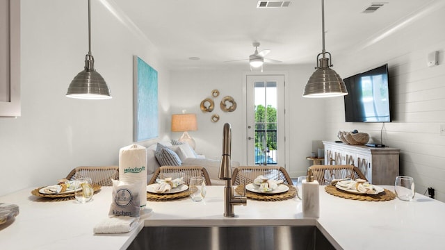 kitchen with ceiling fan, decorative light fixtures, and sink