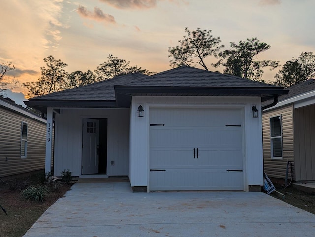 ranch-style house with an attached garage, driveway, and a shingled roof