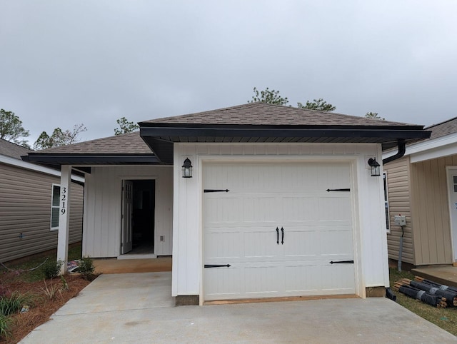 view of front facade with concrete driveway and a shingled roof