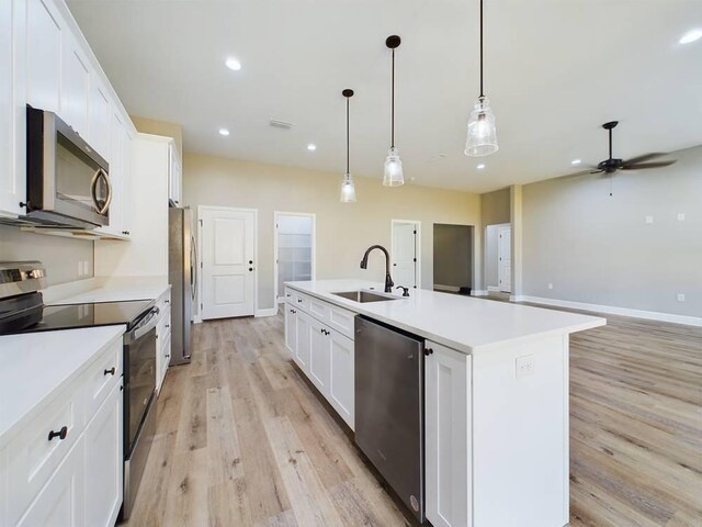 kitchen with white cabinetry, appliances with stainless steel finishes, a sink, and recessed lighting