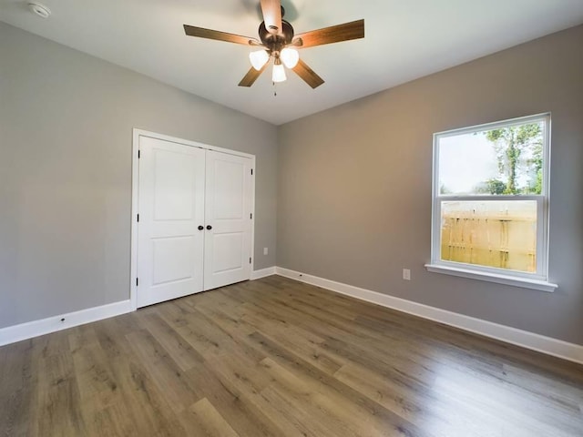 unfurnished bedroom with hardwood / wood-style flooring, a closet, and ceiling fan