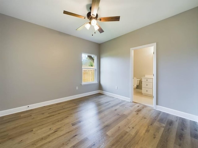 unfurnished bedroom with ceiling fan, light wood-type flooring, connected bathroom, and baseboards