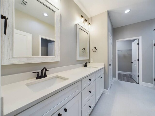 bathroom featuring tile patterned flooring and dual vanity