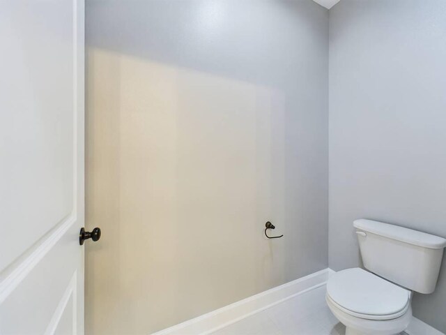 bathroom with toilet and tile patterned floors