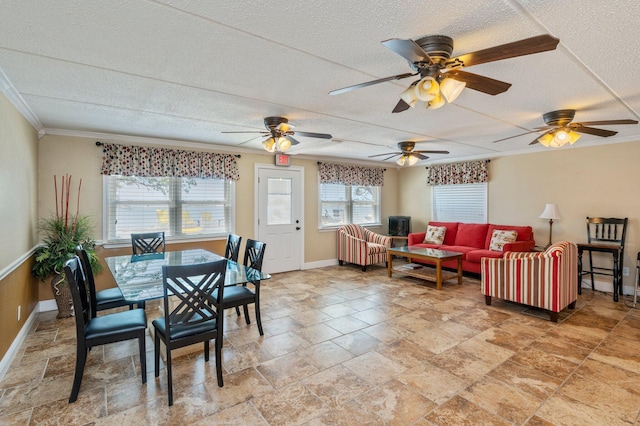 dining area featuring ceiling fan, crown molding, and a textured ceiling