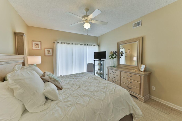 bedroom featuring hardwood / wood-style flooring, ceiling fan, and a textured ceiling