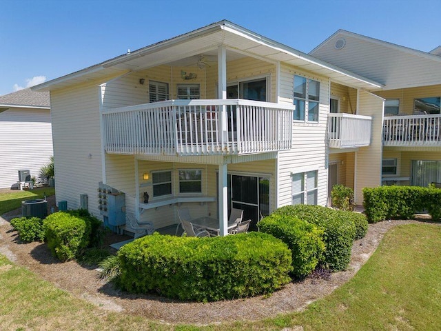 rear view of house featuring a balcony and cooling unit