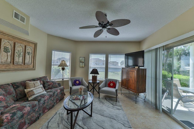 tiled living room featuring ceiling fan and a textured ceiling