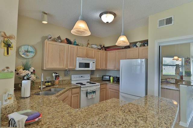 kitchen with light brown cabinetry, sink, white appliances, and kitchen peninsula