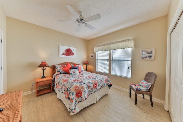 bedroom featuring ceiling fan, a textured ceiling, a closet, and light wood-type flooring