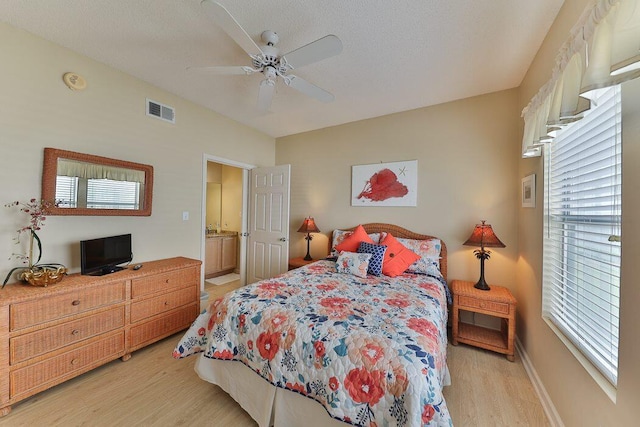 bedroom with multiple windows, ceiling fan, a textured ceiling, and light wood-type flooring